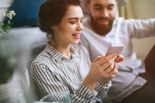 Giovani adulti maschio e femmina con smartphone divertirsi a casa — Foto Stock