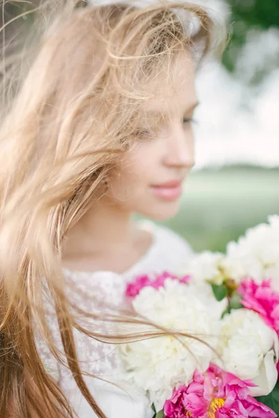 Hermosa mujer joven en vestido blanco al aire libre con flores —  Fotos de Stock