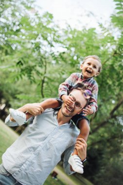 Park açık havada babalar omuzlarında oturan oğlu
