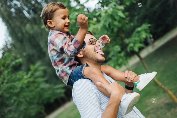 Park açık havada babalar omuzlarında oturan oğlu