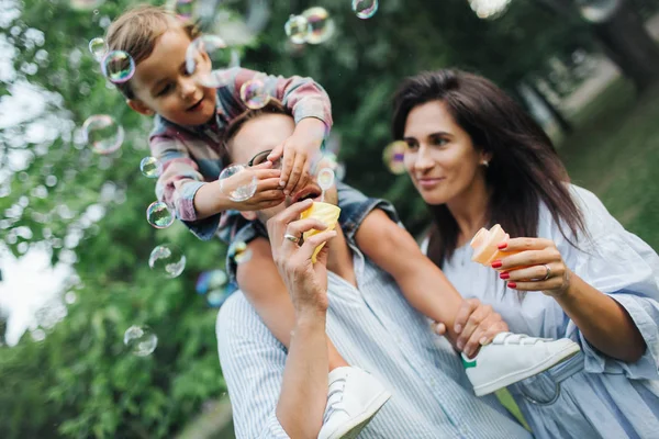 Kabarcık wands Park açık havada oynamaktan mutlu genç aile