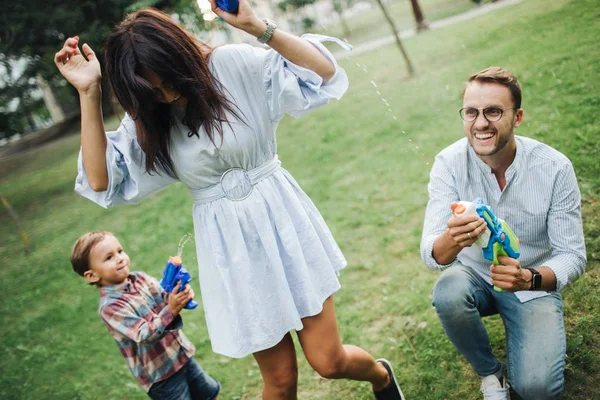 Kisfiú játszik a vízágyúkat a fiatal szülők Park — Stock Fotó