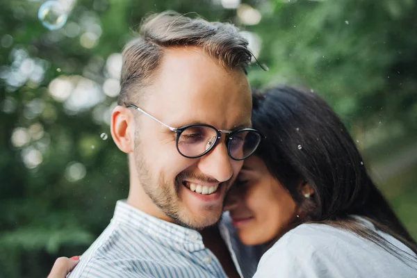 Young pretty couple embrace one another in park — Stock Photo, Image