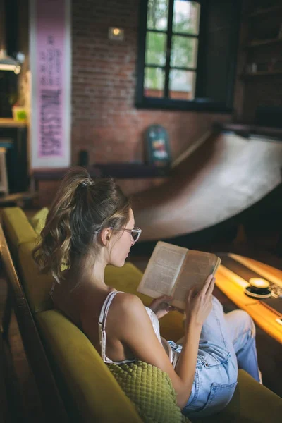 Молодая довольно белая женщина читает книгу в кафе в глазу — стоковое фото