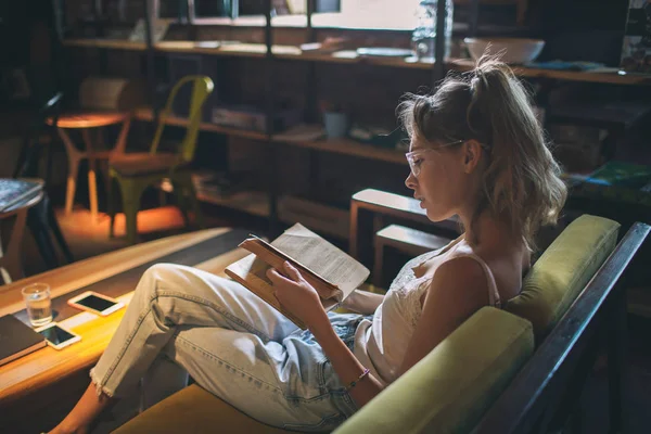 Young pretty caucasian woman reading book in cafe wearing eyegla — Stock Photo, Image