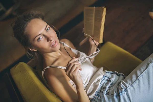 Ung söt kaukasiska kvinna läsebok i café bär eyegla — Stockfoto