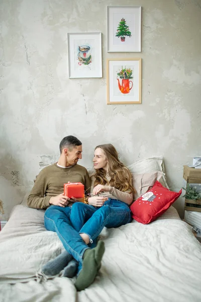 젊은 백인 부부 unboxing 선물 침대에 누워 — 스톡 사진