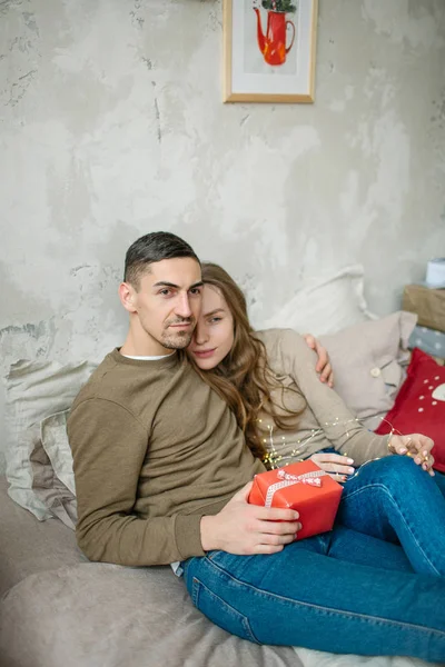 Jovem casal caucasiano unboxing apresenta deitado na cama — Fotografia de Stock