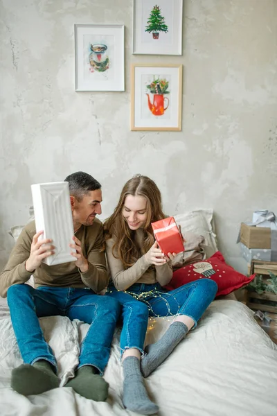 젊은 백인 부부 unboxing 선물 침대에 누워 — 스톡 사진