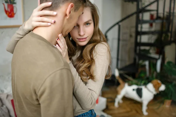 Hombre joven abrazando atractiva mujer rizada en el interior — Foto de Stock