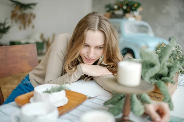 Mladá krásná bruneta žena na jídelní stůl v zařízeném pokoji — Stock fotografie