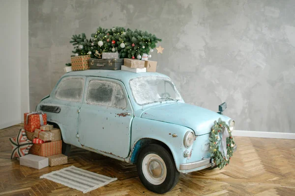 Blaues Retro-Auto mit Weihnachtsbaum auf dem Dach lizenzfreie Stockfotos