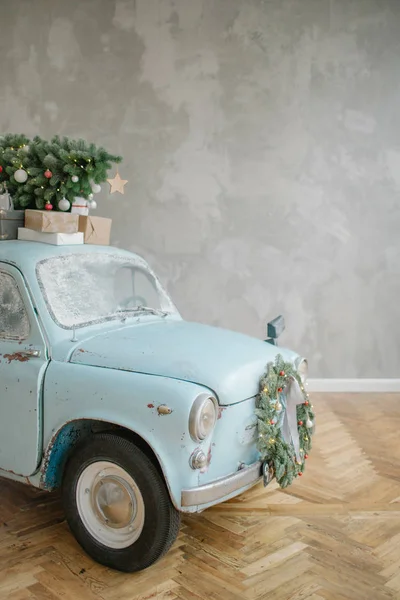Blaues Retro-Auto mit Weihnachtsbaum auf dem Dach lizenzfreie Stockfotos