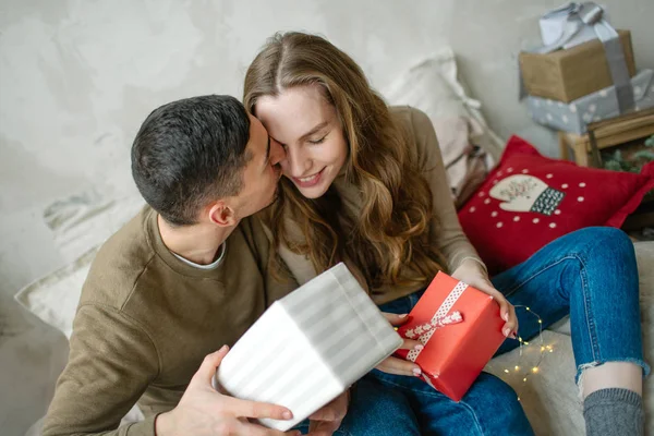 Joven pareja caucásica unboxing regalos por la cama Fotos de stock