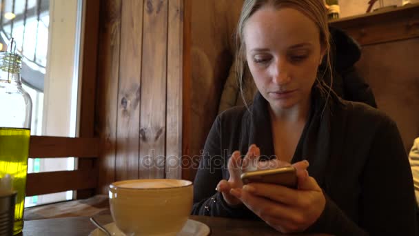 Młoda kobieta przy użyciu telefonu w kawiarni — Wideo stockowe