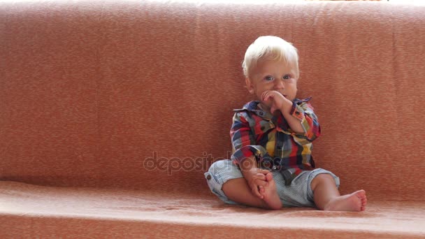 Una niña de un año, envuelta en una toalla, con una cara sucia, sola