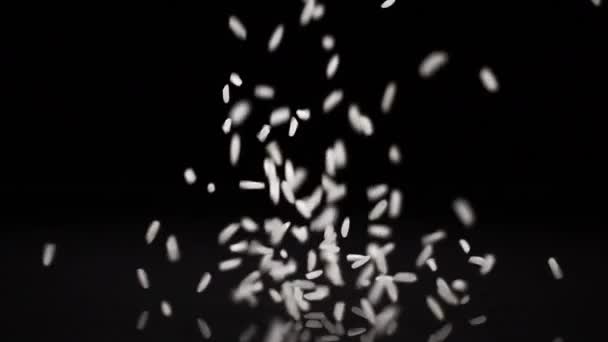 Reis fällt auf eine feste schwarze Oberfläche — Stockvideo