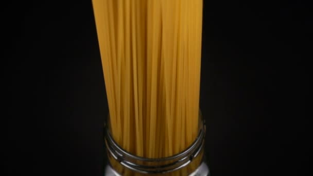 Bunch of spaghetti falls in a glass jar — Stock Video