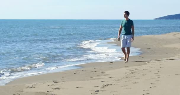 Homem caminhando na praia — Vídeo de Stock