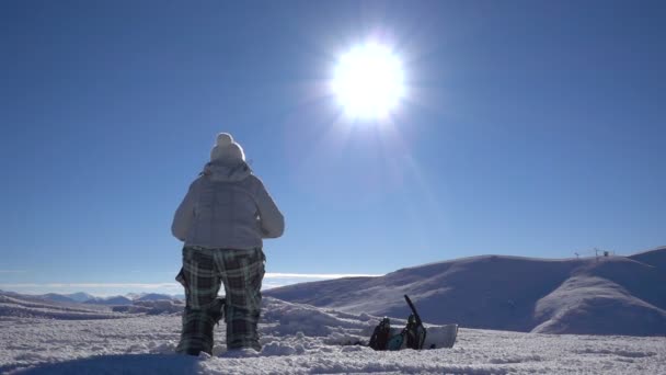 Κορίτσι snowboarder πηδά επάνω στην κορυφή του βουνού — Αρχείο Βίντεο