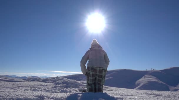 女の子のスノーボーダーが山の上に飛び上がる — ストック動画