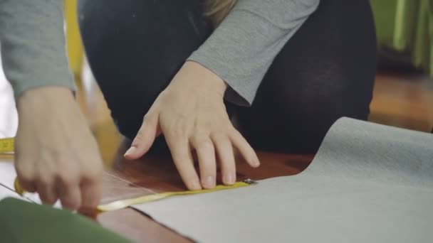 A woman measures and delineates the fabric — Stock Video