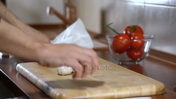Man Pelt knoflook voor het koken van bruschetta — Stockvideo