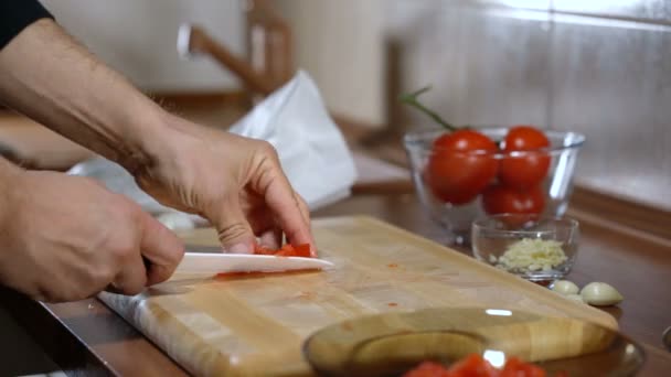 Ο άνθρωπος κόβει μια ντομάτα για μαγείρεμα Μπρουσκέτα — Αρχείο Βίντεο