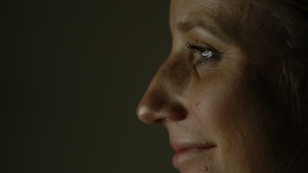 Το πρόσωπό του μια γυναίκα που κάθεται στο σκοτάδι μπροστά από μια οθόνη υπολογιστή — Αρχείο Βίντεο