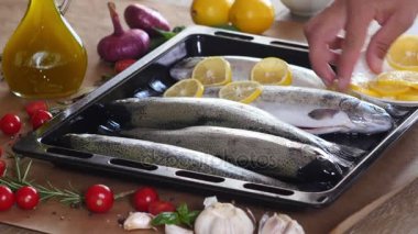 Şef bir alabalık fırında pişirme için hazırlar