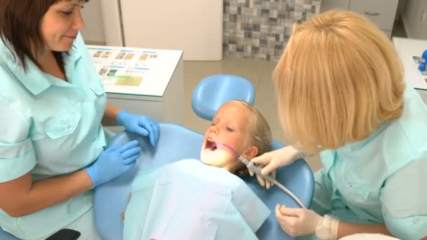 Niña sentada en el consultorio de dentistas — Vídeos de Stock