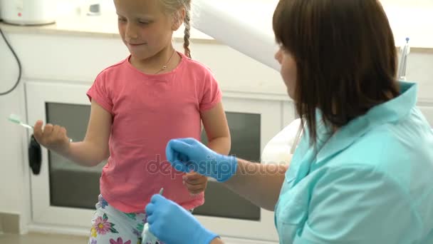 Маленька дівчинка сидить у стоматологічному кабінеті — стокове відео