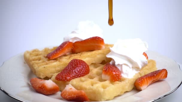 Gieten van ahornsiroop op wafels met aardbeien — Stockvideo