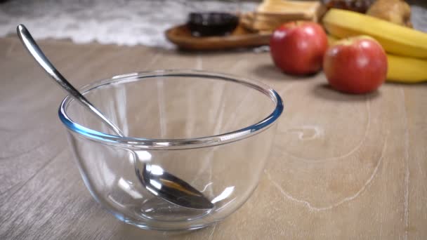 Flocos de milho são derramados em uma tigela de vidro com leite — Vídeo de Stock