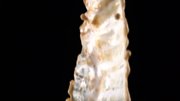 Verser du café et du lait et faire des éclaboussures sur fond noir 