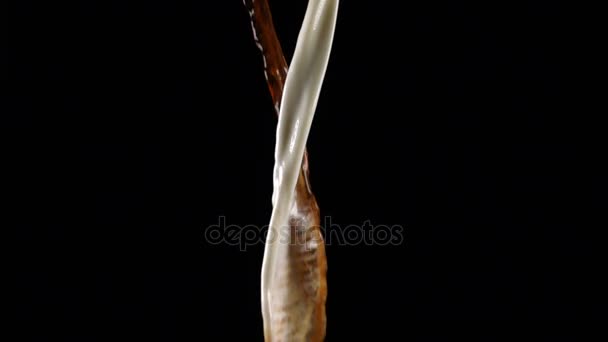 Verser du café et du lait et faire des éclaboussures sur fond noir 