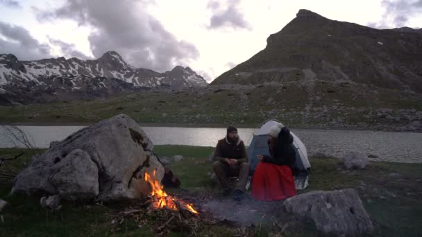 Couple of travelers at dusk near a campfire — Stock Video