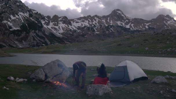 Paar von Reisenden in der Abenddämmerung am Lagerfeuer — Stockvideo