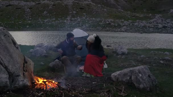 Paar von Reisenden in der Abenddämmerung am Lagerfeuer — Stockvideo