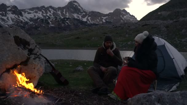 Bir kamp ateşi yakın alacakaranlıkta gezginlerin Çift — Stok video