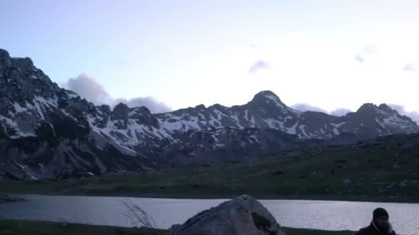 Un par de viajeros al atardecer cerca de una fogata — Vídeos de Stock