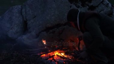 Bir kamp ateşi yakın alacakaranlıkta gezginlerin Çift