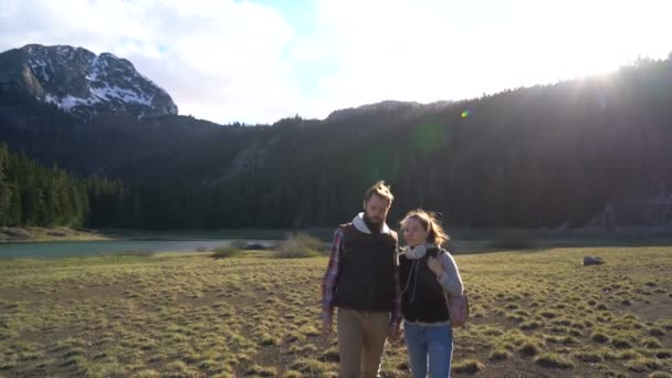 Joven pareja caminando a lo largo del lago — Vídeos de Stock