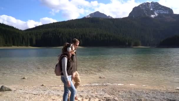 Joven pareja caminando a lo largo del lago — Vídeos de Stock