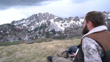 Uzun yürüyüşe çıkan kimse oturur ve bir termos sıcak çay içer