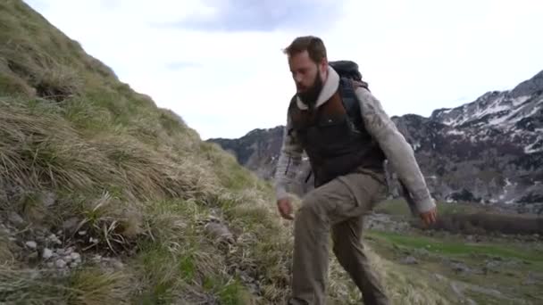 Caminhante escalando as encostas da montanha — Vídeo de Stock