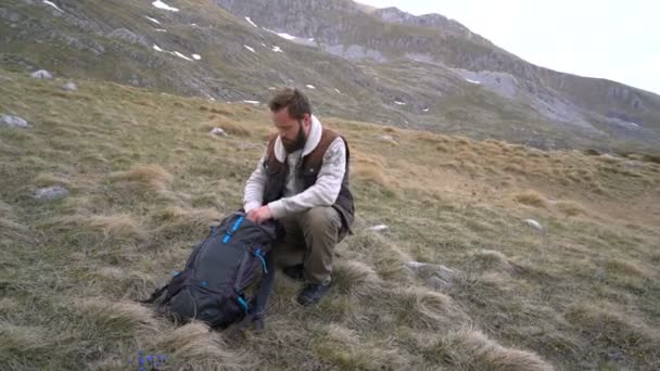 L'escursionista si siede e beve il tè caldo da un thermos — Video Stock