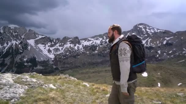 Caminhante indo ao longo da encosta gramada — Vídeo de Stock