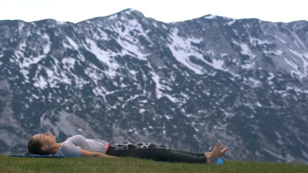 Egy nő jógázik a szabadban. — Stock videók