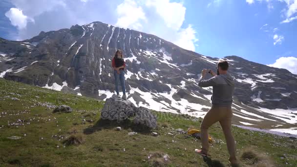 Boyfriend takes pictures of his girlfriend outdoors — Stock Video